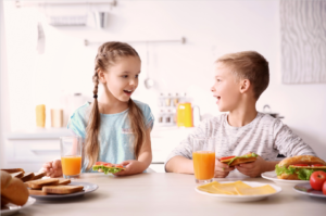 Two children preparing a meal at table