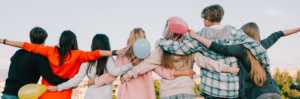 Seven youth embracing with backs to camera